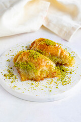 Sobiyet baklava with pistachio on a white wooden background. Baklava on a marble floor.