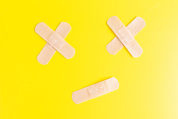 Sticking plasters on yellow background, top view. Adhesive plaster medical. Isolated object.