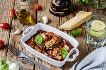 Fototapeta na wymiar Parmigiana is Italian dish with eggplants, tomatoes sauce, garlic, basil and cheese