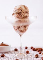 Chocolate ice cream in a glass with ingredients used to decorate the background