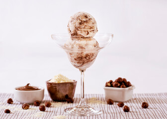 Powdered milk ice cream with chocolate in a glass with ingredients used to decorate the background
