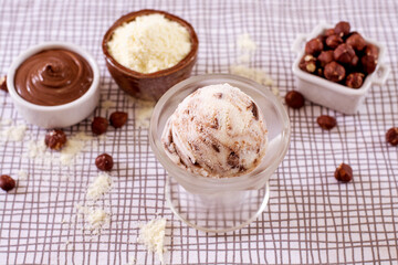 Powdered milk ice cream with chocolate in a glass with ingredients used to decorate the background