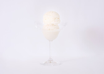 Coconut ice cream in a bowl with grated coconut decoration in the background