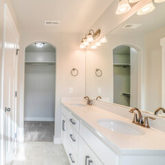 Square frame Interior of a white bathroom with shower with glass wall, sink and empty closet
