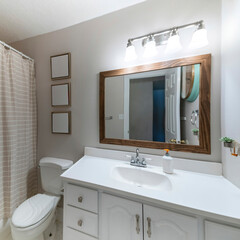 Square frame Bathroom interior with vanity sink, frames and closed shower curtain