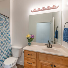 Square frame Bathroom with wooden vanity sink with flower vase and mirror