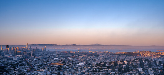 A picturesque panorama of the city of San Francisco at a bright beautiful sunset from Twin Peaks hill.