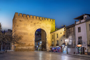 Granada, Spain. View of historic Gate of Elvira (Puerta de Elvira) at dusk