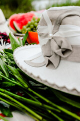 Fruits, berries, chamomile flowers and a hat are lying on the bedspread