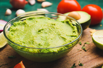 Bowl with tasty guacamole and nachos on table, closeup