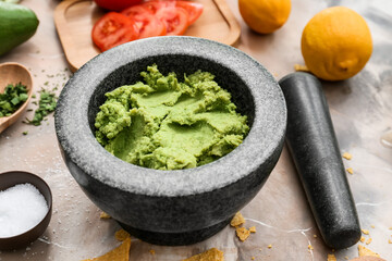 Mortar with tasty guacamole on color background, closeup