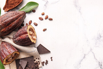 Fresh cocoa fruits, beans, powder and chocolate on light background