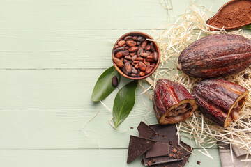 Composition with fresh cocoa fruits, beans, powder and chocolate on color wooden background