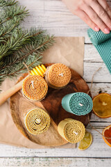 Handmade wax candles on light wooden background