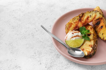 Plate with grilled pineapple slices and ice cream on light background
