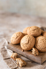 Oatmeal cookies on wooden cutting board, brown concrete background. Healthy snack or dessert.