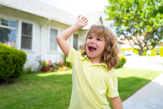 Boy with good bye or hello sign outdoor. Kids with funny face bye bye hand on backyard. Emotional child.