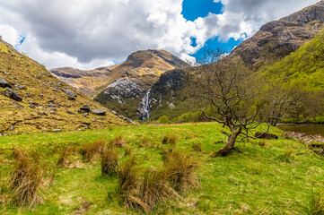 A view from a bend in the River Nevis towards the Steall Waterfall in Glen Nevis, Scotland on a summers day