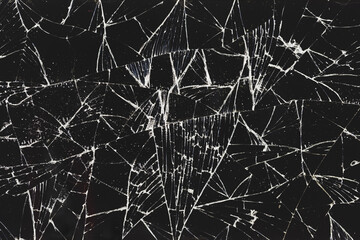 Broken, cracked glass on a black background as texture, pattern, background. Cracked smartphone screen.	