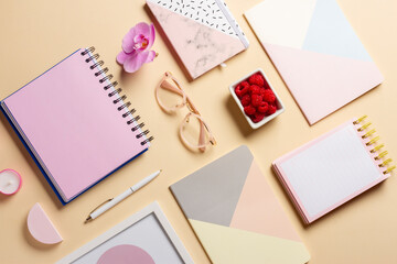 Composition of notepads, pen, flower, raspberries and candles on a delicate background