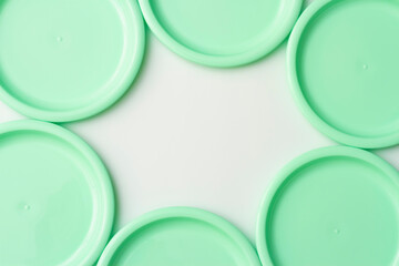 Plastic dishes in mint color on white background