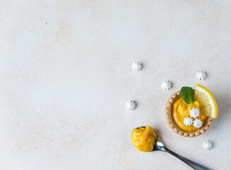 Shortbread mini tart with lemon curd, mint and lemon slices and mini meringue, light concrete background. Top view. Copy space. - obrazy, fototapety, plakaty