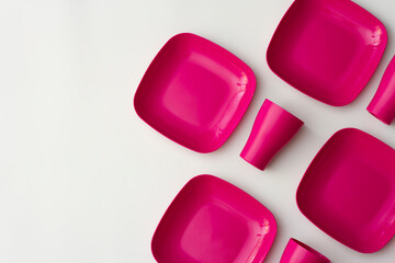 Purple plastic plates and cups on a bluish background