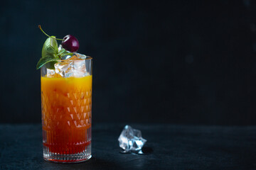 Cold juice with ice mint and cherries in a glass