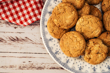 Aerial view of part of a plate with oatmeal cookies with raisins and seeds with copy space. Natural nutrition concept.