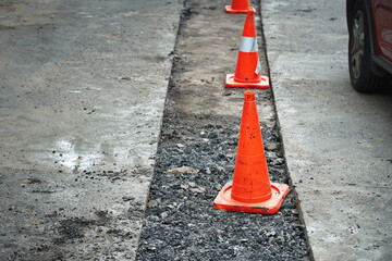 Preparing for patch works. Repair pothole in asphalt pavement, road work warning cones. Roadwork,...