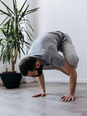 A male yogi with a beard doing yoga asanas and sports exercises for a strong and flexible body