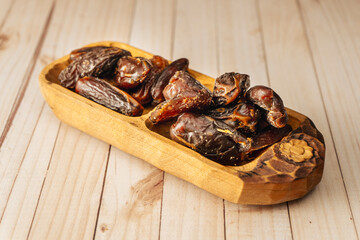 Fresh dates in a wooden platter on a table. Normal view, Concept healthy and natural food