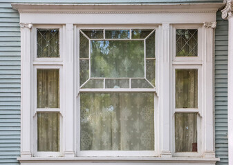 Antique detailed beveled window on a classic Victorian house