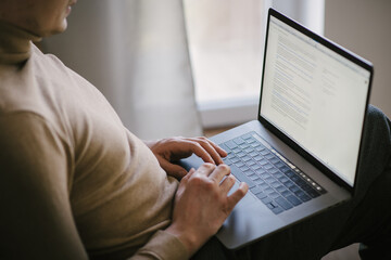 close up of a man working on a laptop