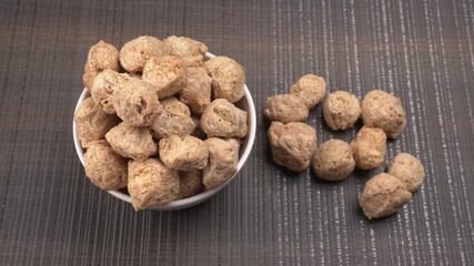 Raw soya chunks on dark background. Healthy, nutritious soybean meat, chunks isolated.Vegan food concept.