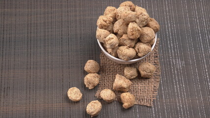 Raw soya chunks on dark background. Healthy, nutritious soybean meat, chunks isolated.Vegan food concept.