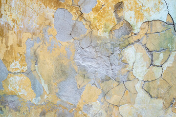 damaged weathered multicolored coating of paint of concrete building wall with many patches