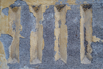 damaged weathered concrete coating of fainted paint of building wall with many patches