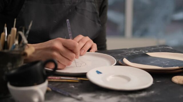 Process of plate decoration with color pattern by woman