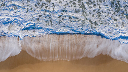 Aerial top view of shore waves washing the sand of the beach in Andalusia, Spain. Spanish sand...