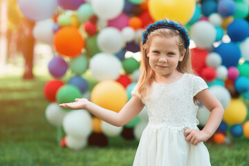A little girl demonstrates the emotions of happiness. The child rejoices in the festive atmosphere