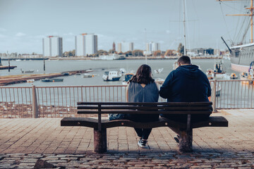 A couple sitting on a bench together at the seaside