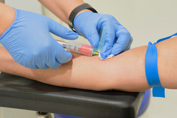 Nurse takes a blood sample, with a prick on the forearm of a patient. Rapid antibody diagnostic...