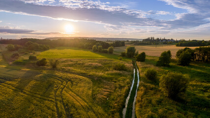 view of the landscape with traces of a tractor on a calm, summer early evening in the Czech Republic