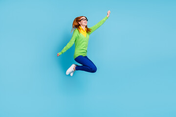 Full length profile photo of young funny millennial lady jump wear spectacles sweater trousers isolated on blue color background