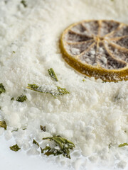 a handful of pink coarse sea salt with dried flowers and bath lime