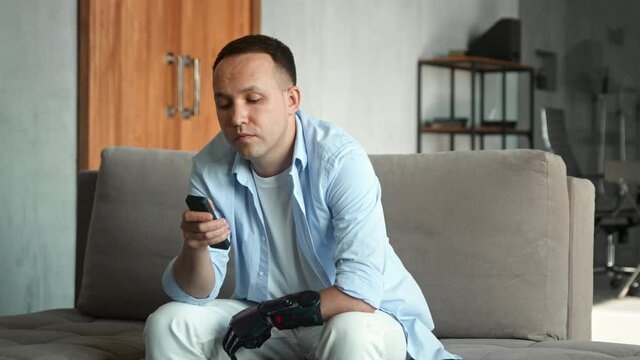 Bored man with hi tech bio limb prothesis switches channels