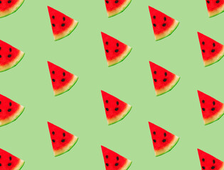 Creative composition made with watermelon slices on pastel green background. Summer fruit pattern.
