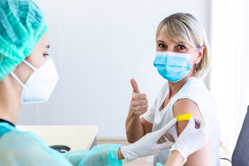 woman wearing mask getting vaccinated concept of coronavirus vaccination mask grown woman approved for covid-19 vaccination at the hospital. Female doctor immunizes against the virus,  medical plaster