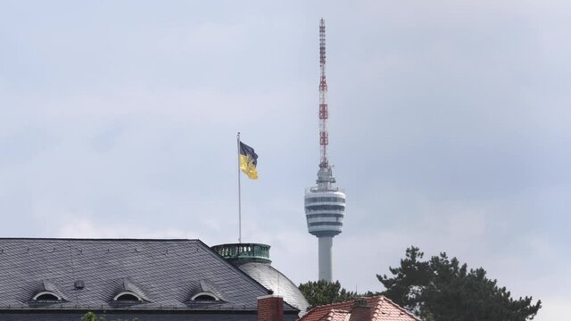 Baden Württembergische Flagge im Wind mit Fernsehturm im Hintergund. 
